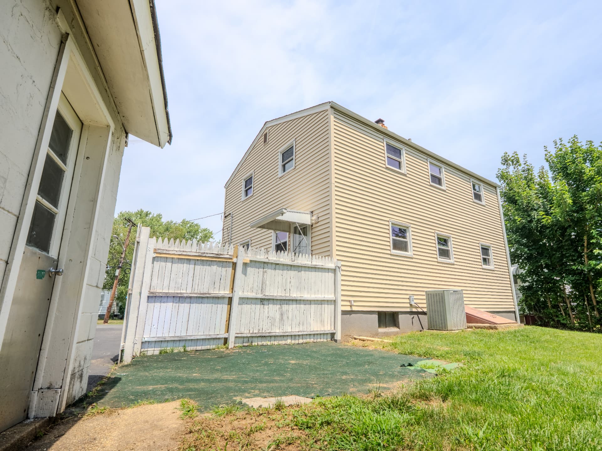 Side and rear exterior view of a two-story home with a fenced yard